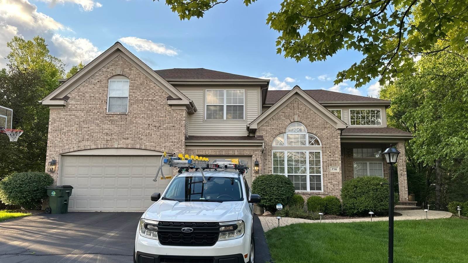 Pane Pal service truck parked at a brick two-story home in Palatine, IL before an exterior window cleaning